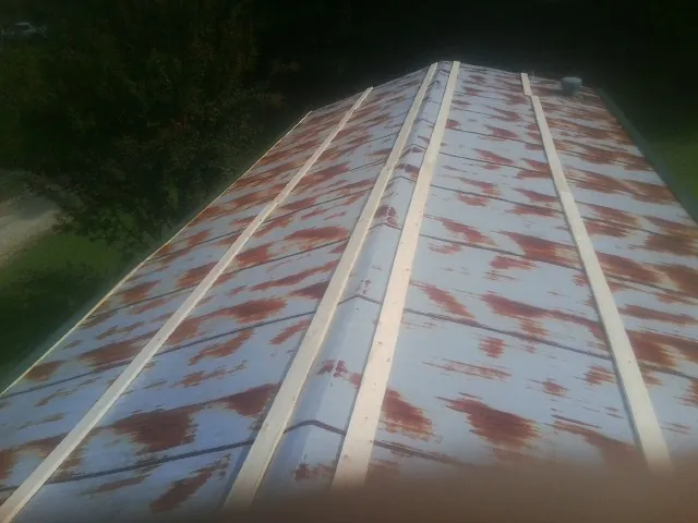 Rusted metal roof panels with new wood purlins before replacement — Storm Damage Roof Repair in Oaklyn by Roofing Brothers