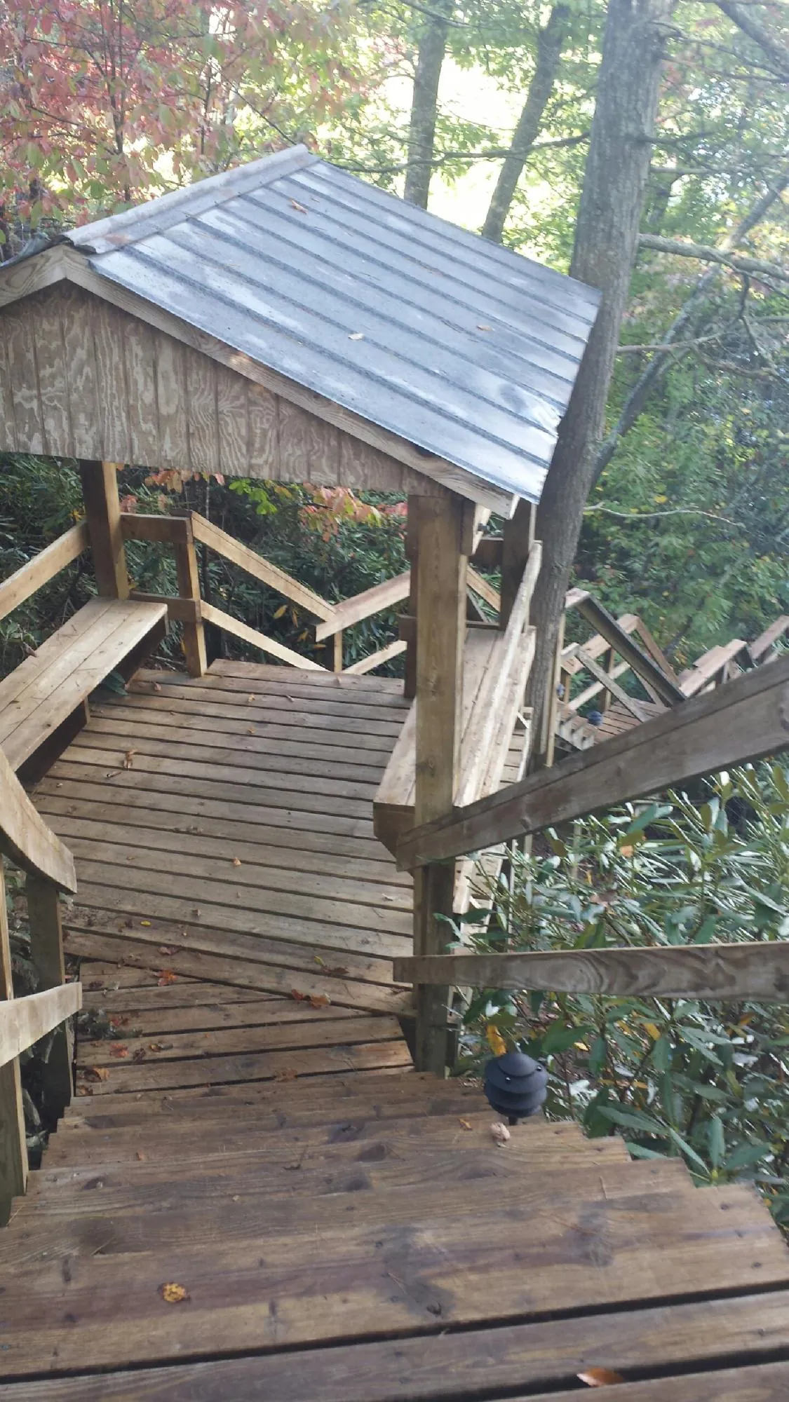 Metal roofed shelter over wooden steps on a wooded walkway — Skylight Repair & Installation work by our crew in Oaklyn